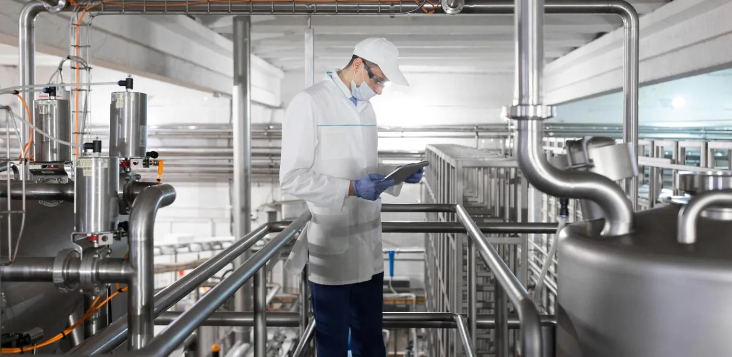 Manager reviewing plans in industrial setting.