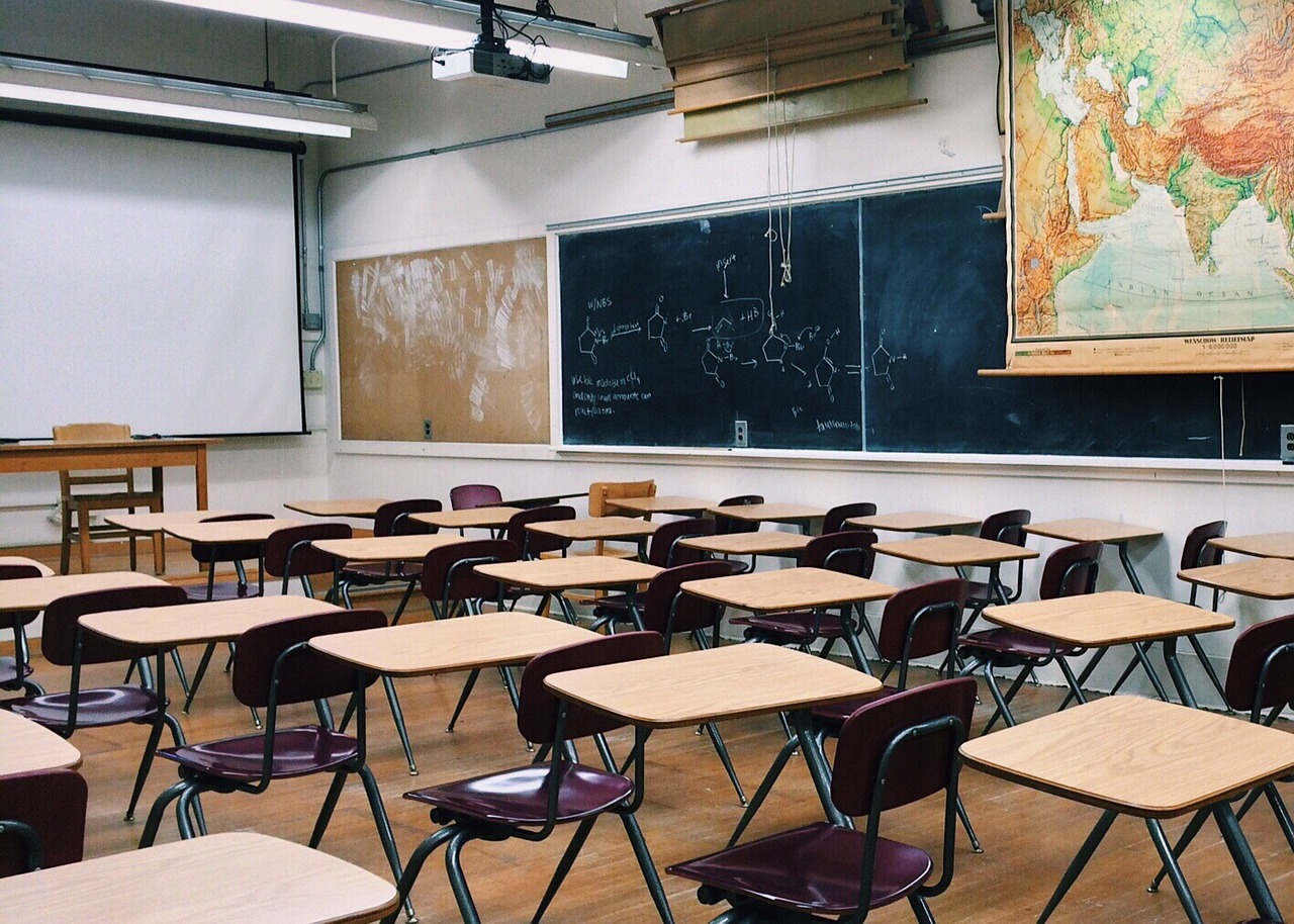 Empty classroom with desks and map.