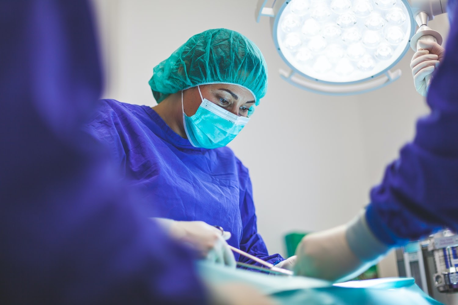 Surgeon performing operation in scrubs