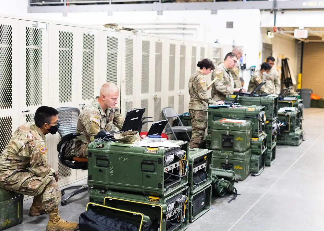Insights Blog 3 Military personnel using portable equipment indoors.