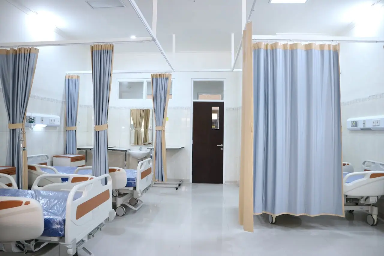 Insights Blog 9 Hospital patient ward with multiple beds, privacy curtains, and clinical care equipment.