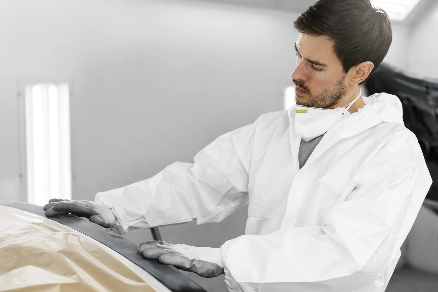 Insights Blog 8 Man in protective suit working on car