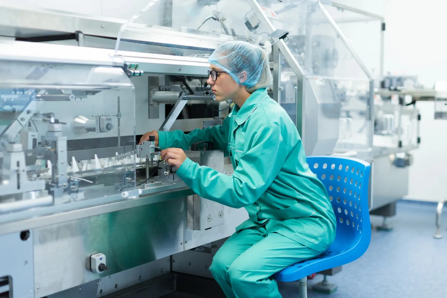 Insights Blog 7 Pharmaceutical worker in protective clothing operating machinery in a cleanroom, illustrating controlled production and electrostatic risk management.