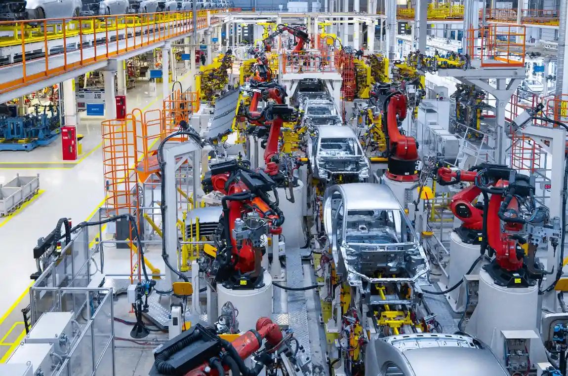 Insights Blog 1 Automated automotive assembly line with robotic arms assembling car bodies in a vehicle manufacturing plant.