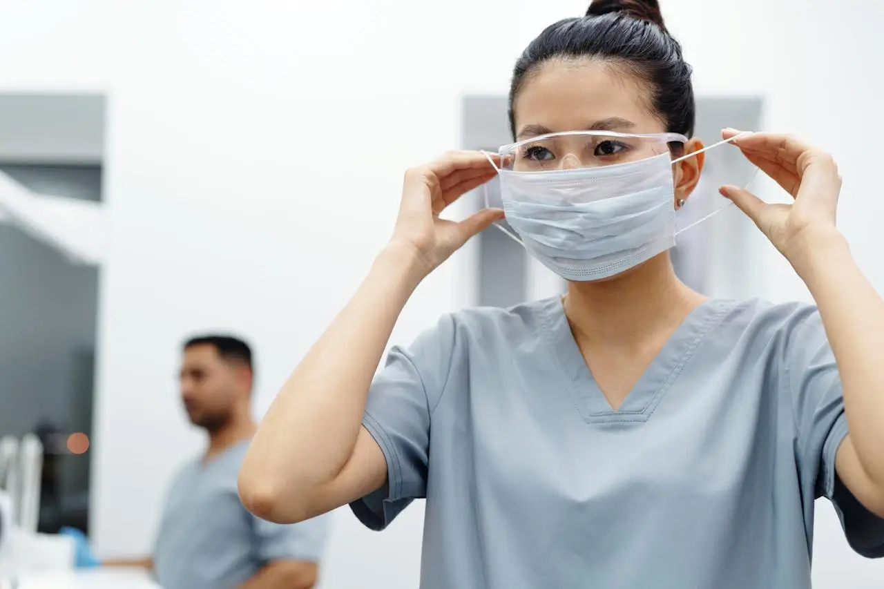 Insights Blog 4 Healthcare worker wearing a protective mask and face shield in a hospital clinical environment.