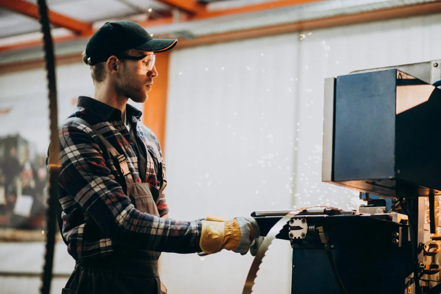 Insights Blog 9 Commercial manufacturing worker operating industrial equipment inside a factory production area.