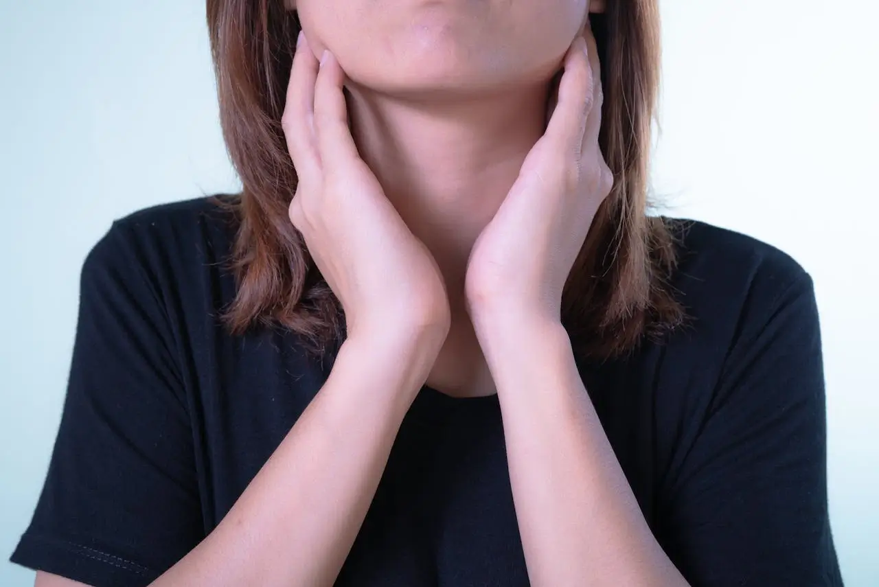Person holding neck showing discomfort from dry throat and irritation
