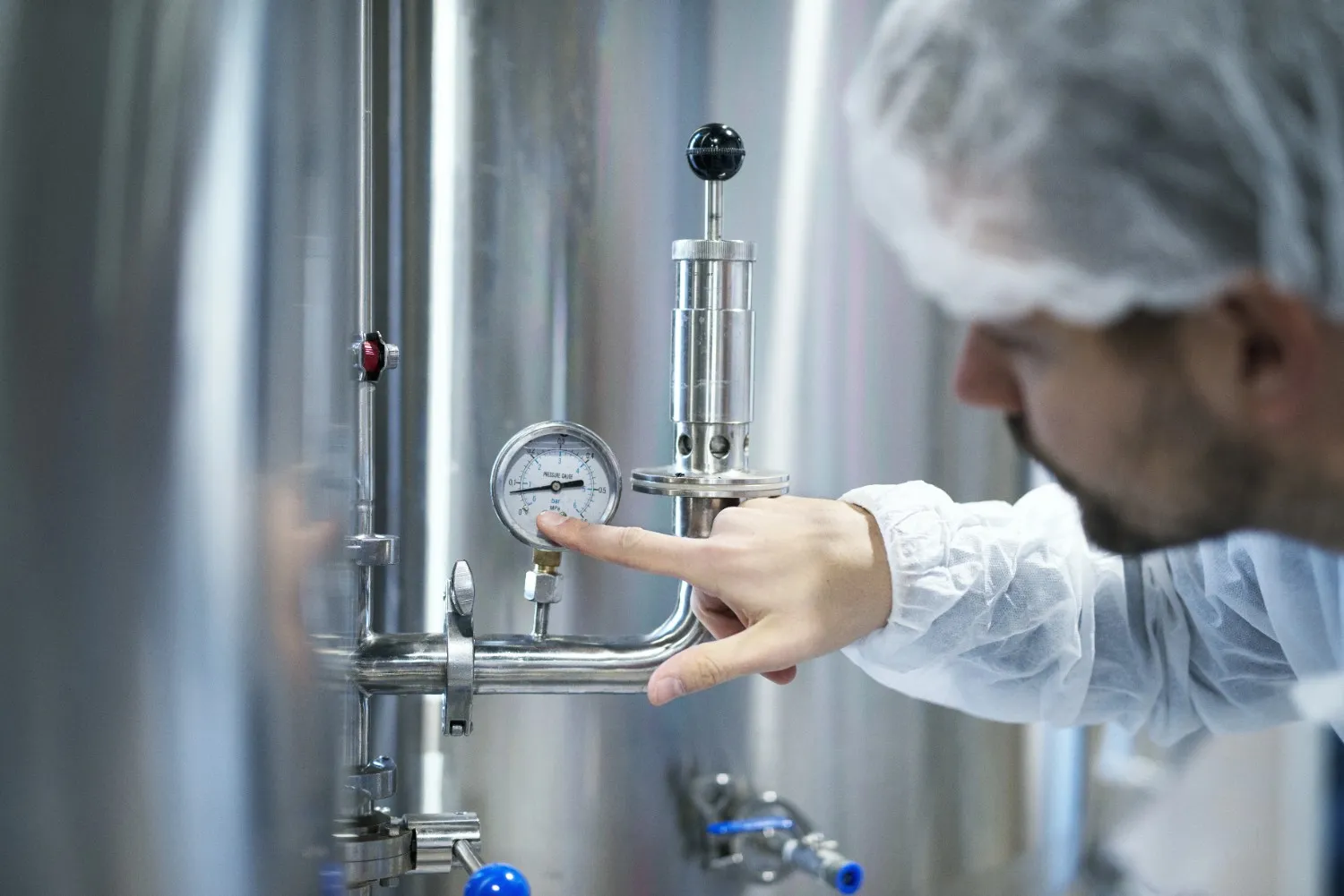 Insights Blog 8 Industrial technician checking pressure and control equipment in a humidity-controlled production environment.