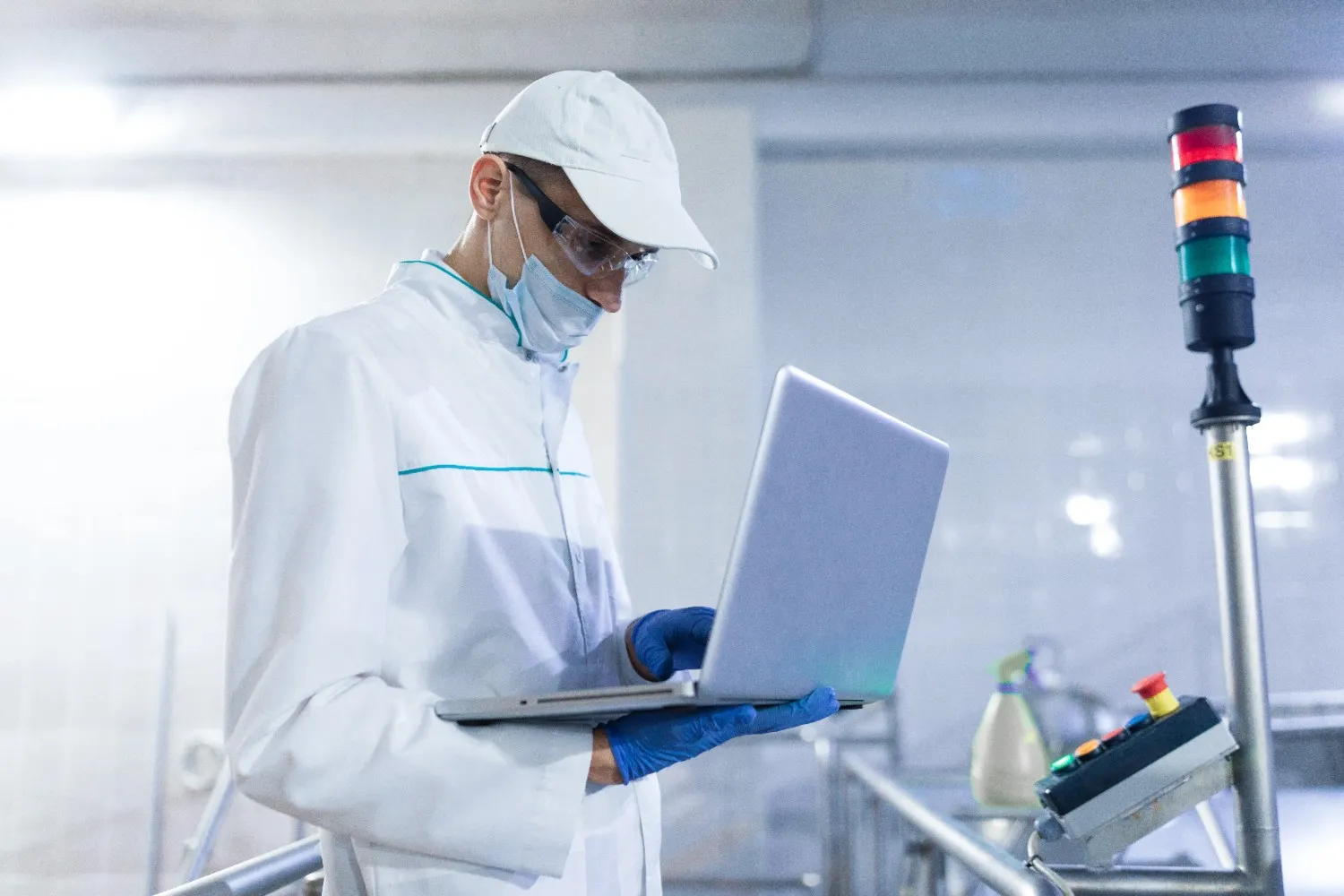 Insights Blog 2 Pharmaceutical technician using a laptop in a controlled manufacturing environment, illustrating design and monitoring of GMP-compliant systems.