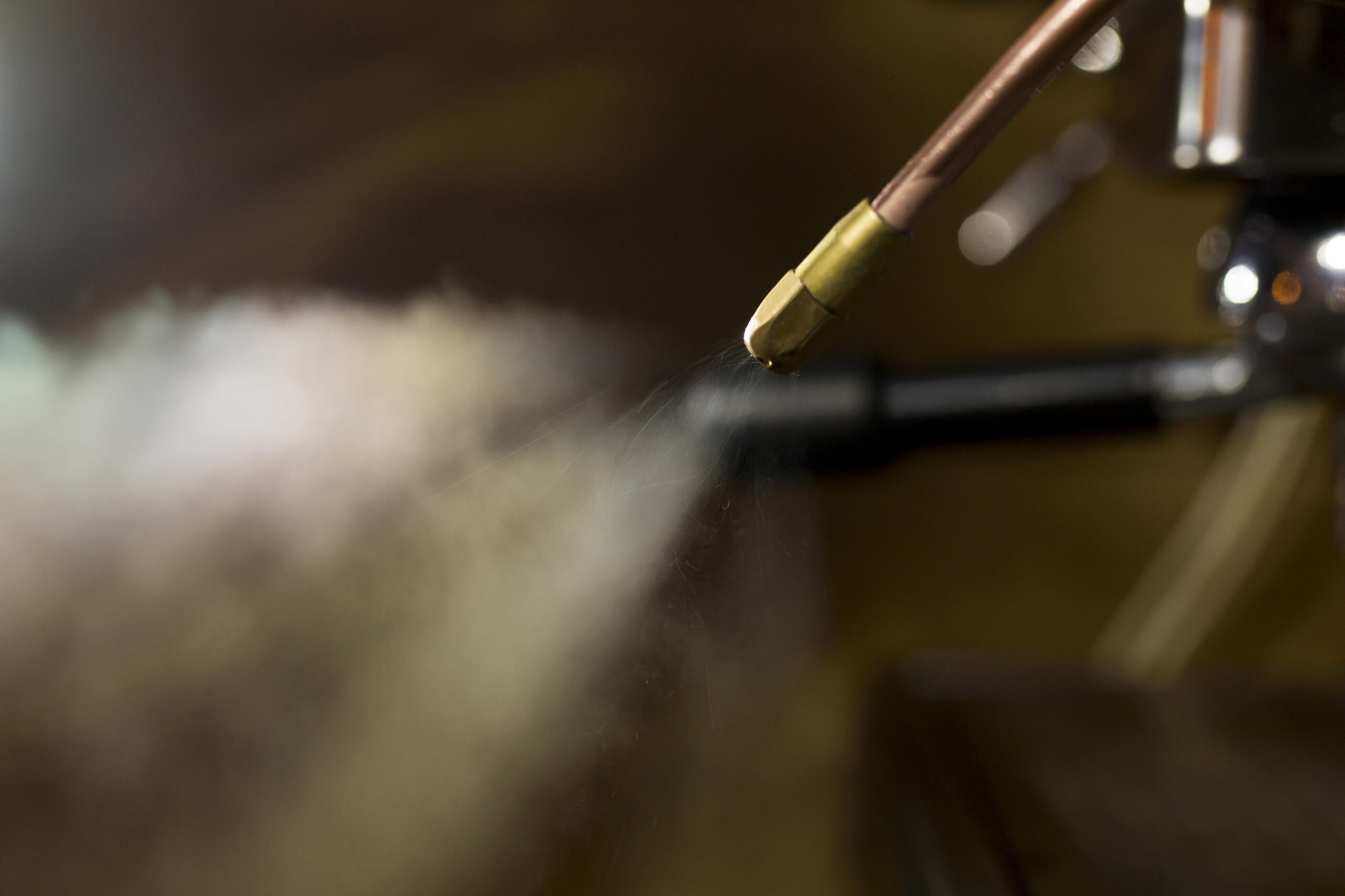 Insights Blog 9 Close-up of a misting nozzle releasing a fine spray of water droplets, demonstrating atomization technology used in mist systems for cooling, humidification, and environmental control applications.