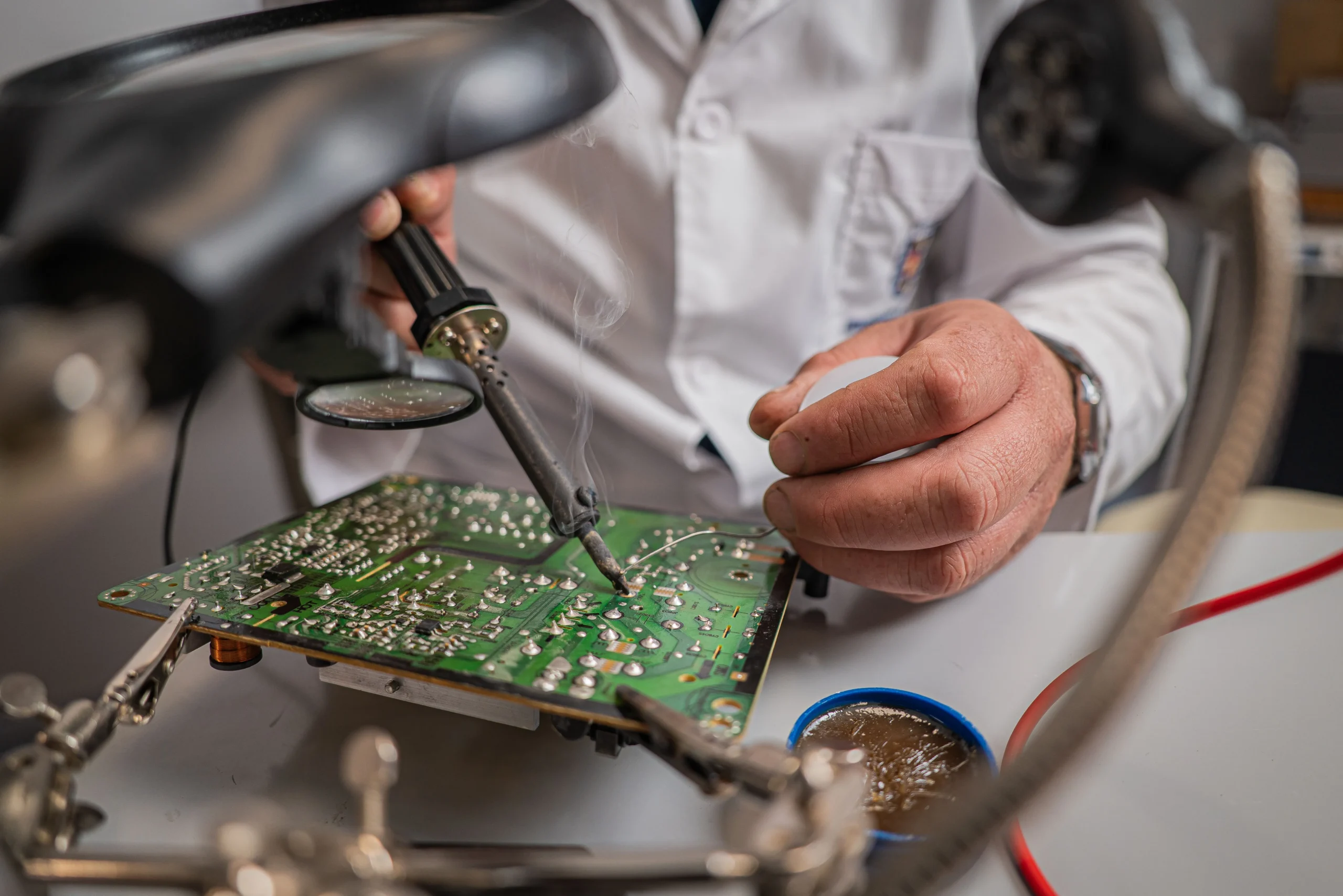 Insights Blog 4 Technician using a soldering iron to repair a printed circuit board during precision electronics assembly.