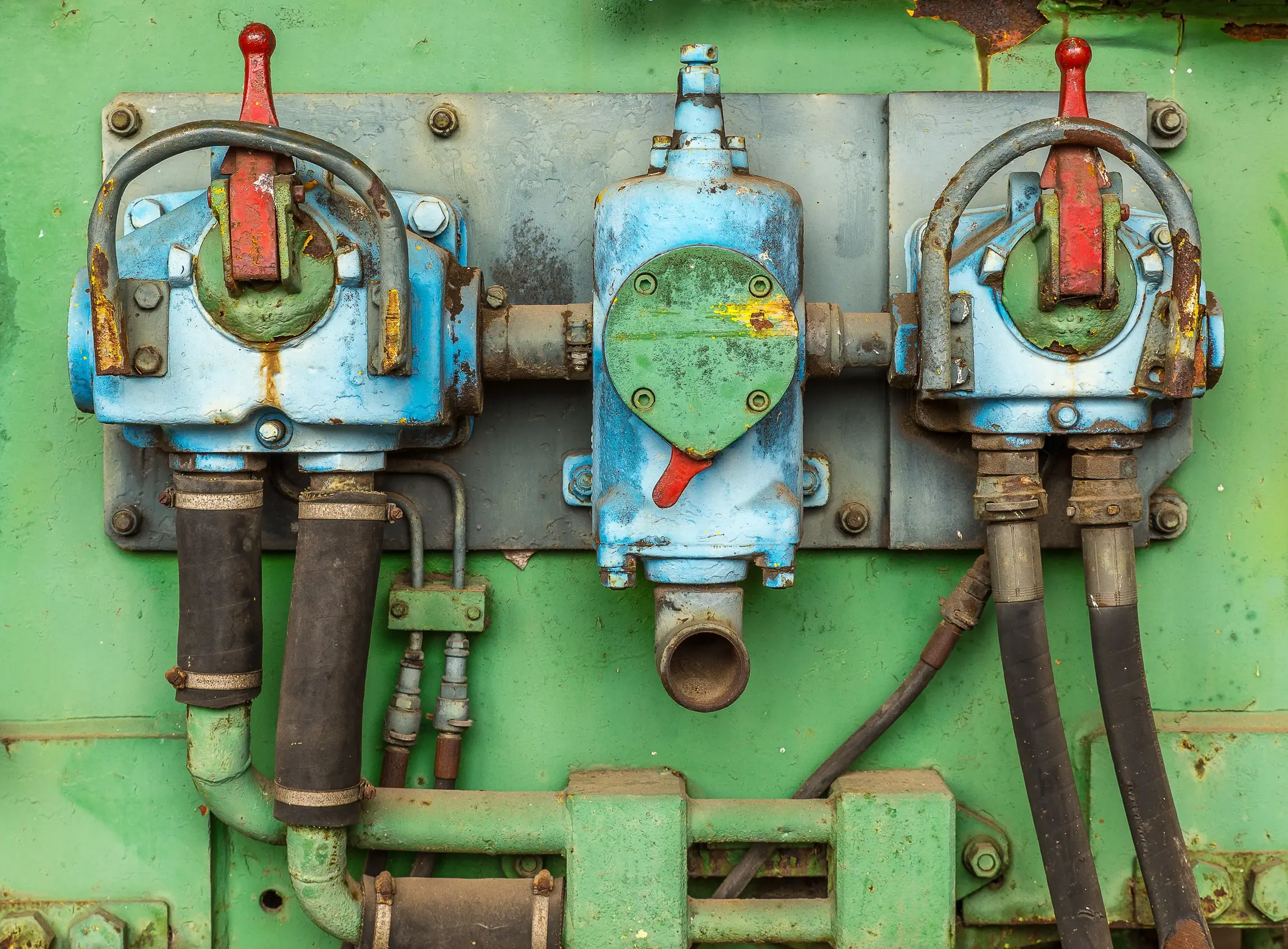 Insights Blog 8 Close-up of weathered industrial solenoid valve assemblies with control levers, electrical connections, and pipe fittings showing signs of corrosion and wear in a factory environment.