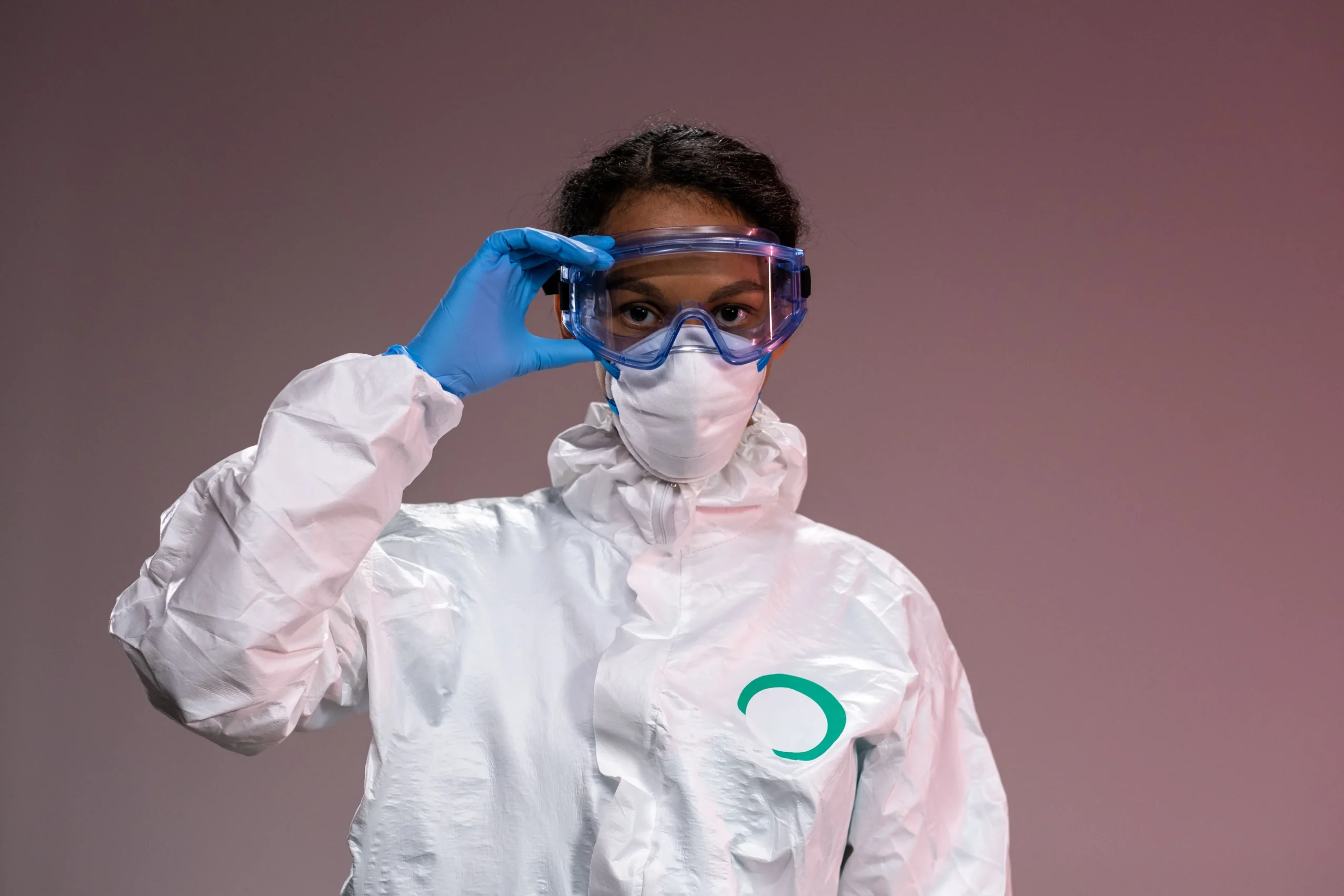 Insights Blog 6 Worker wearing full protective coveralls, gloves, safety goggles, and a face mask, demonstrating personal protective equipment used during chemical disinfection, biosecurity, and contamination control procedures.