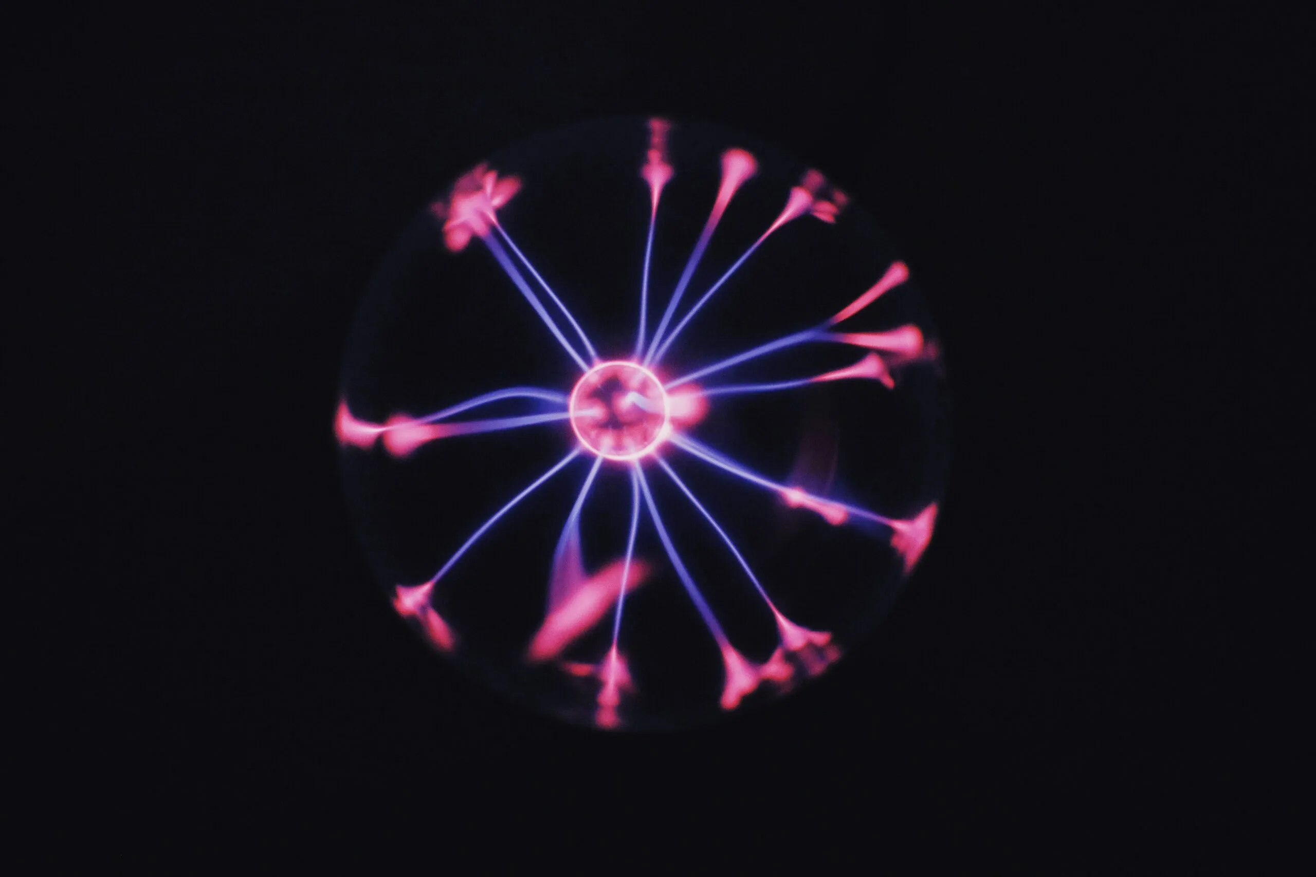 Insights Blog 8 Plasma globe displaying visible electrical discharge streams radiating from a central electrode, illustrating electrostatic charge generation and ionization principles used in static control technologies.