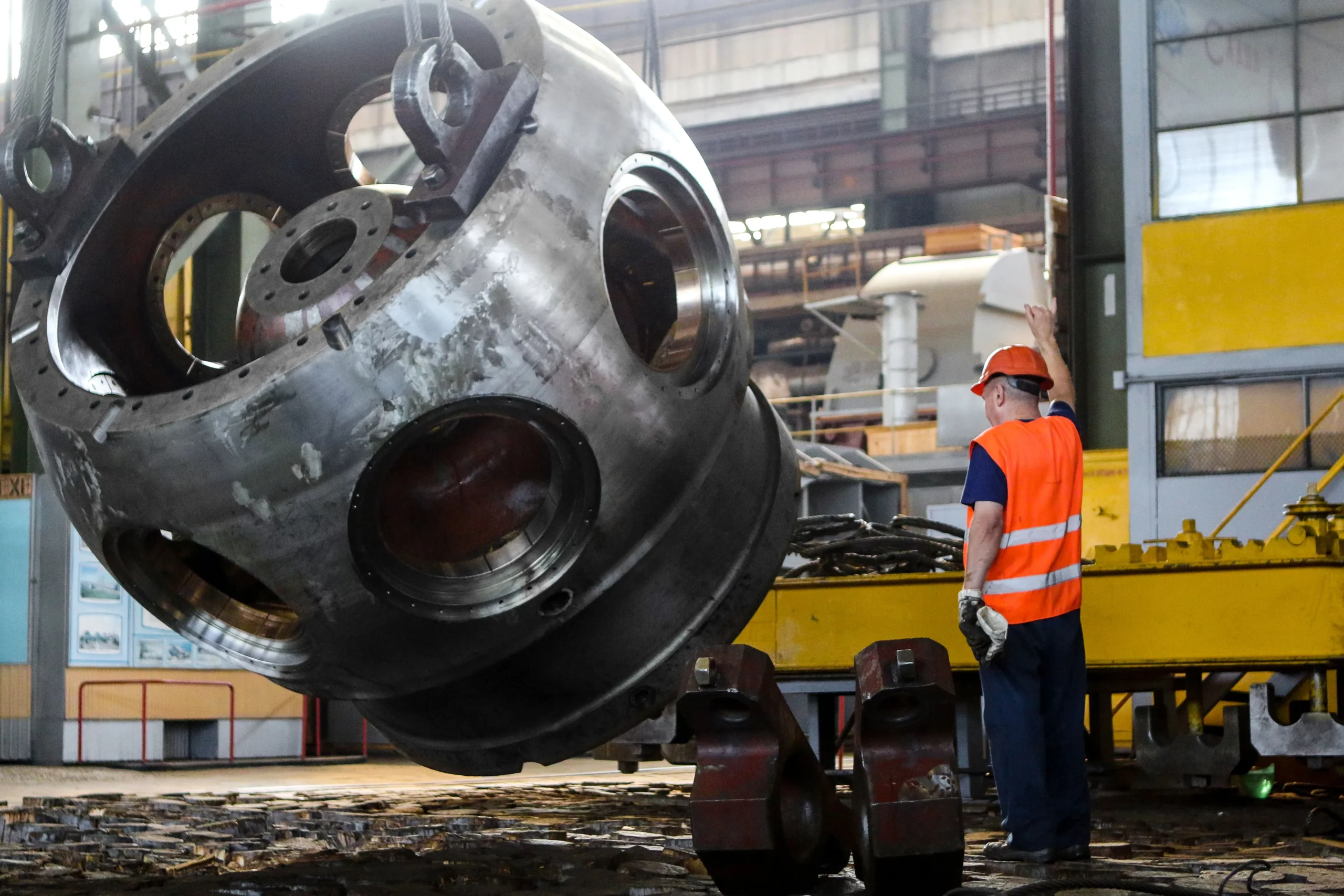 Insights Blog 1 Industrial worker overseeing the lifting of a large machined metal component in a heavy manufacturing facility, illustrating precision engineering environments where accurate humidity control helps protect equipment and maintain production conditions.