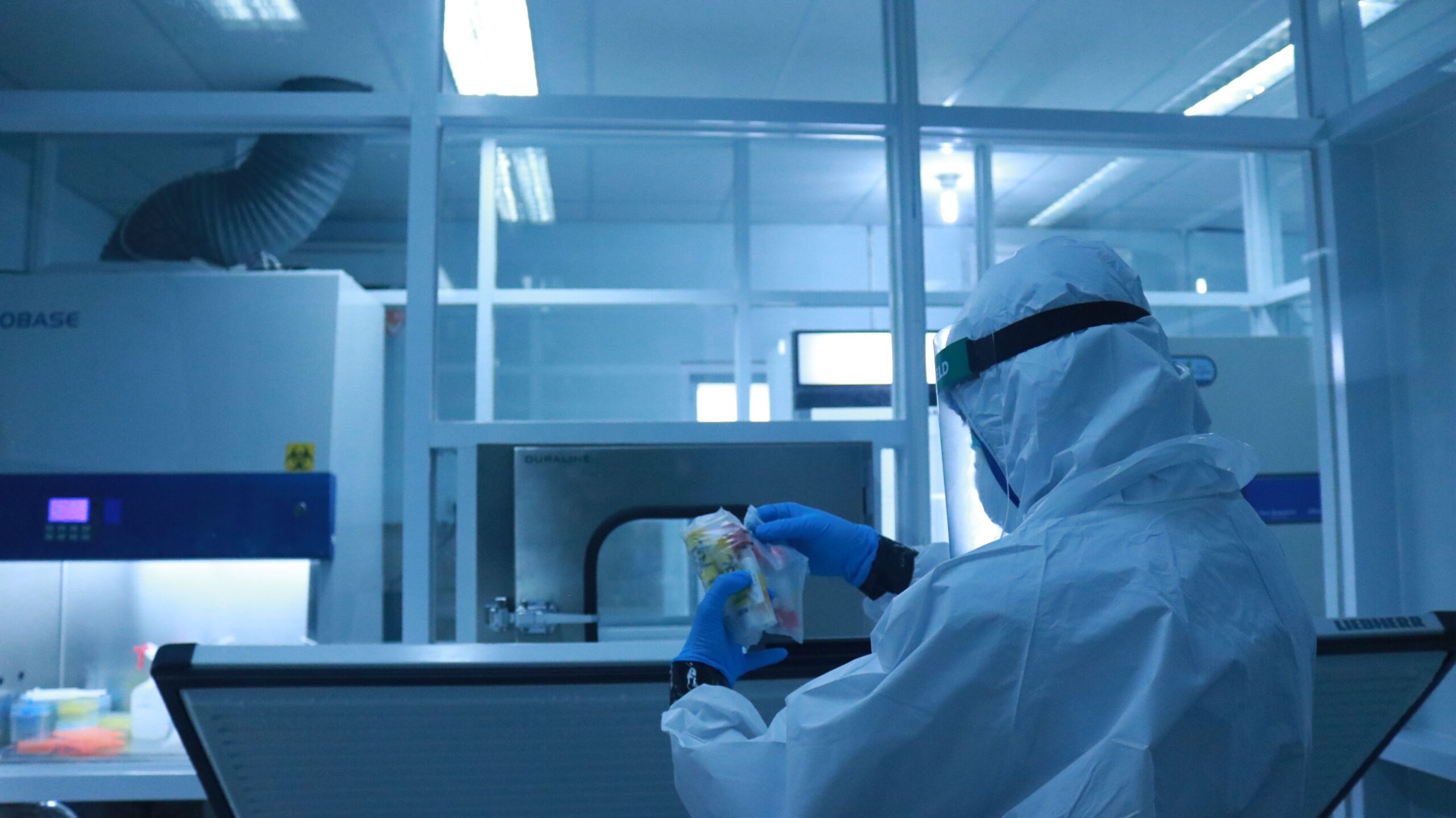 Insights Blog 2 Technician in cleanroom protective gear handling electronic components inside an electronics manufacturing facility.