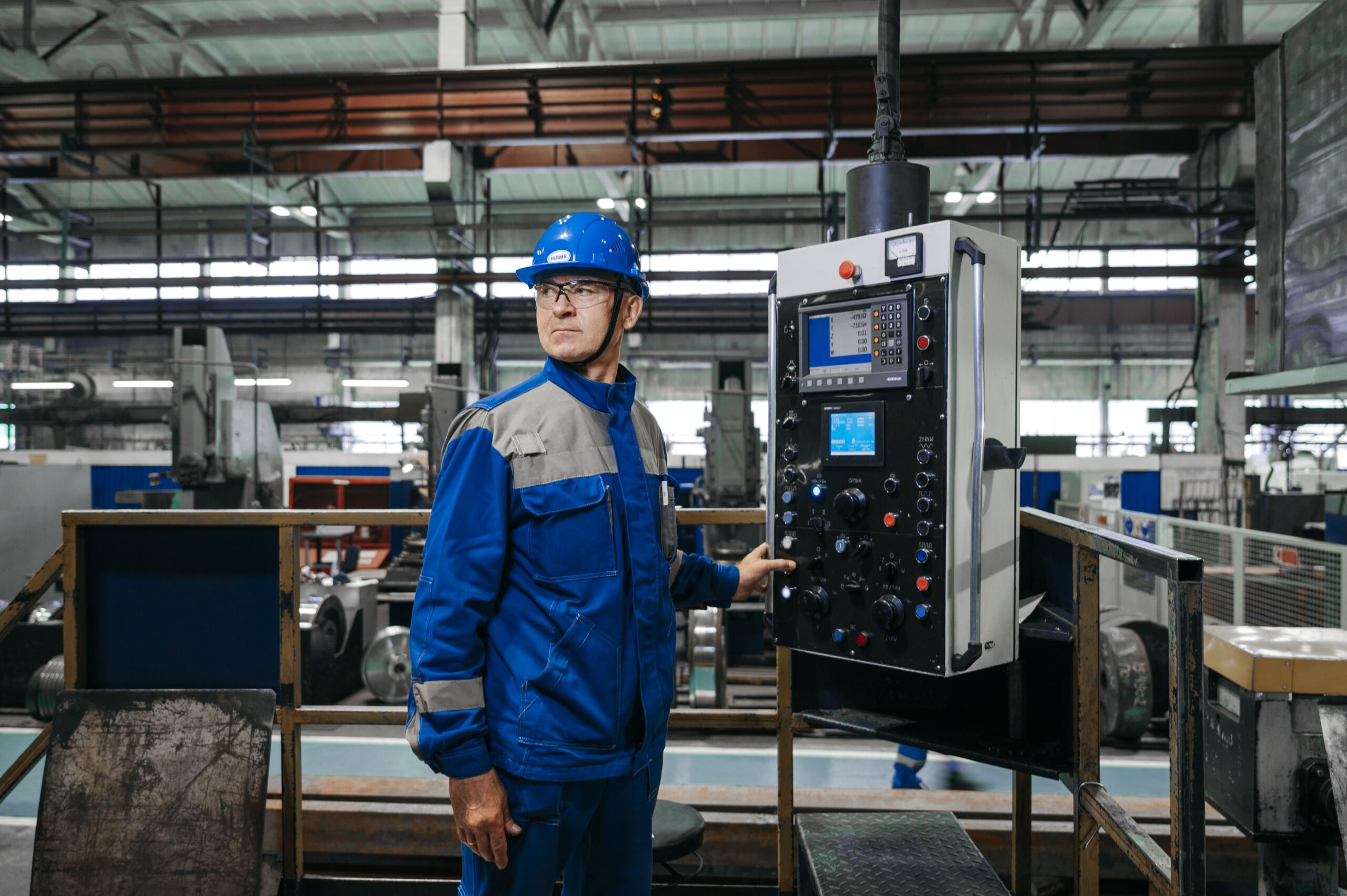 Insights Blog 7 Industrial engineer operating a control panel on a factory production floor, representing commercial building and manufacturing environments where humidity control supports indoor air quality and occupant comfort.
