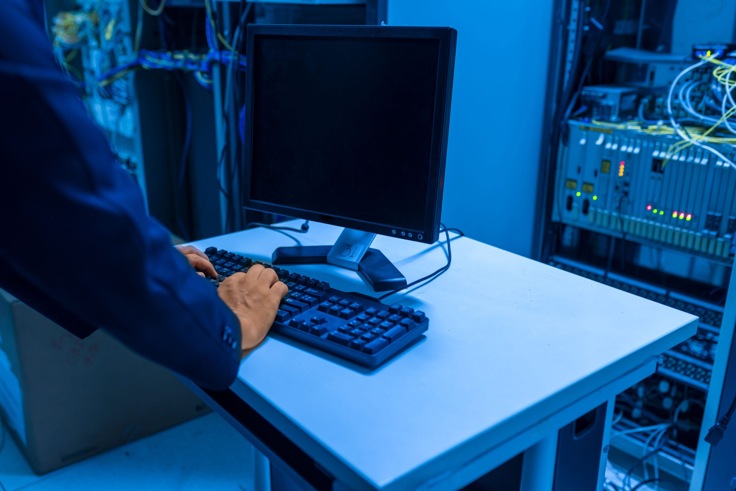 Insights Blog 9 Technician working in an industrial facility among equipment racks, representing the layered ESD control methods used to prevent static electricity damage