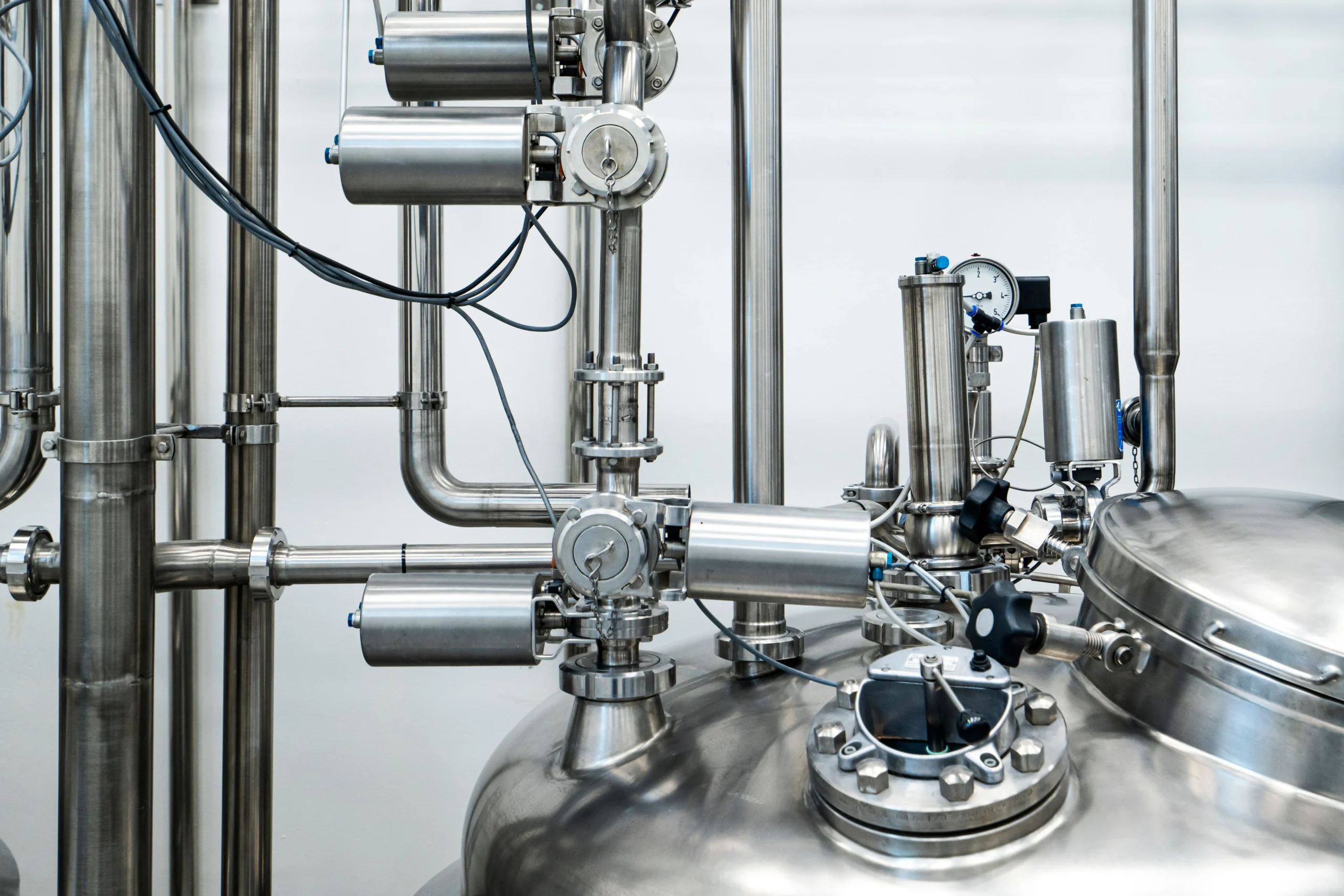 Home Page 3 Close-up of stainless steel industrial process equipment with pressure gauge and pneumatic valve actuators, representing the precision instrumentation used to measure and control humidity in industrial and pharmaceutical facilities