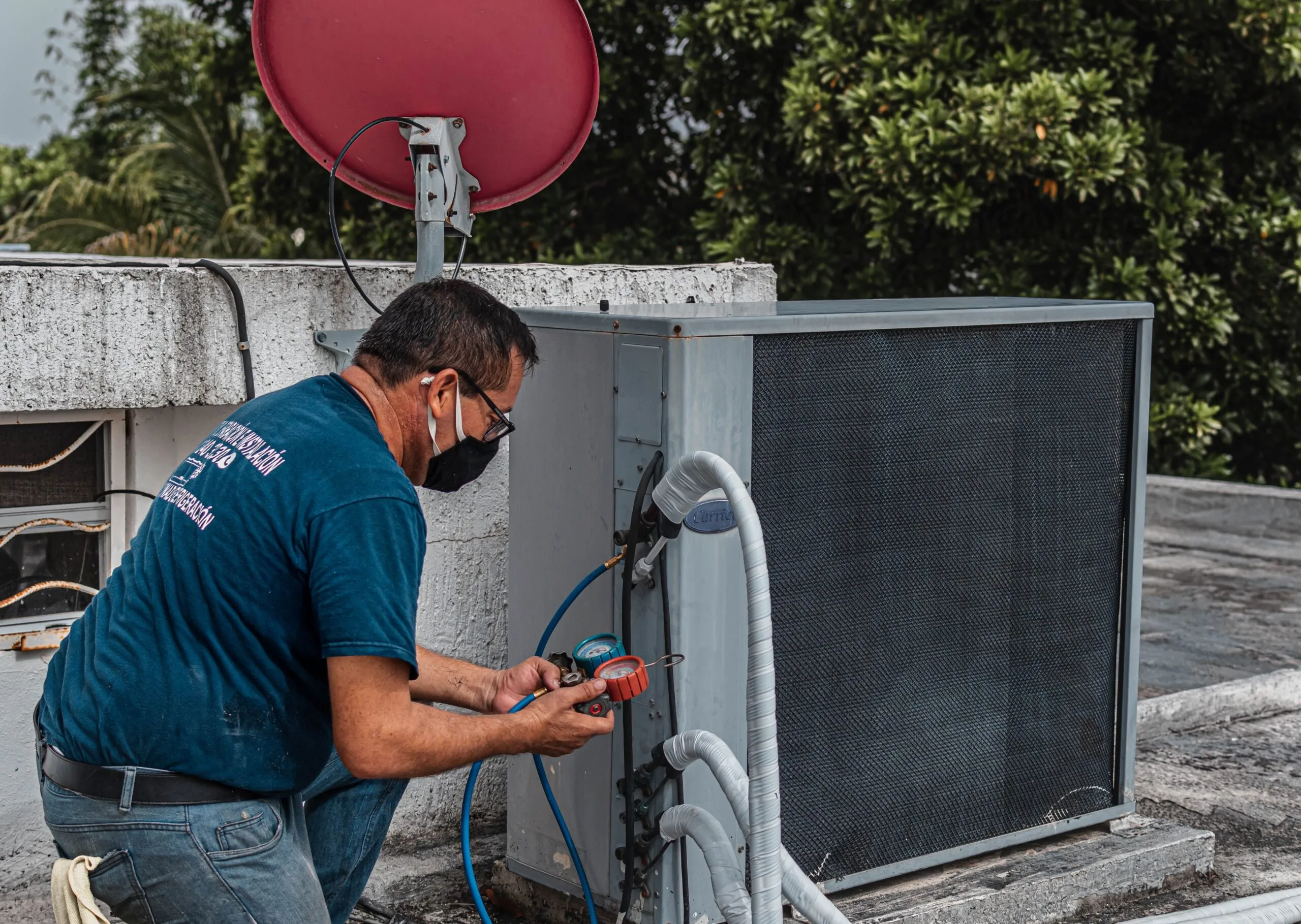 HVAC technician servicing a rooftop condenser, representing the cooling equipment sized by enthalpy load calculations,