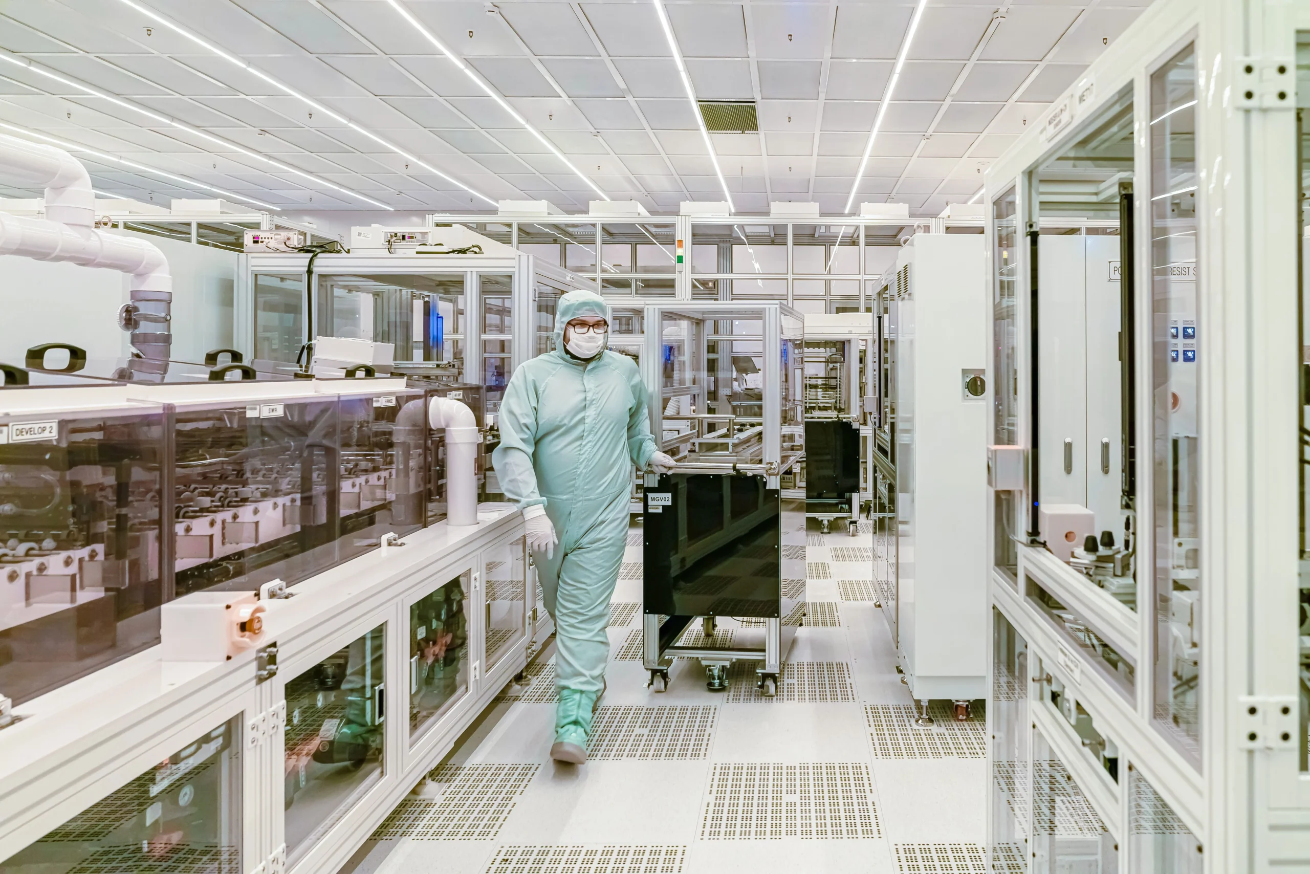 Technician in a semiconductor cleanroom, where humidity control prevents ESD and contamination risk