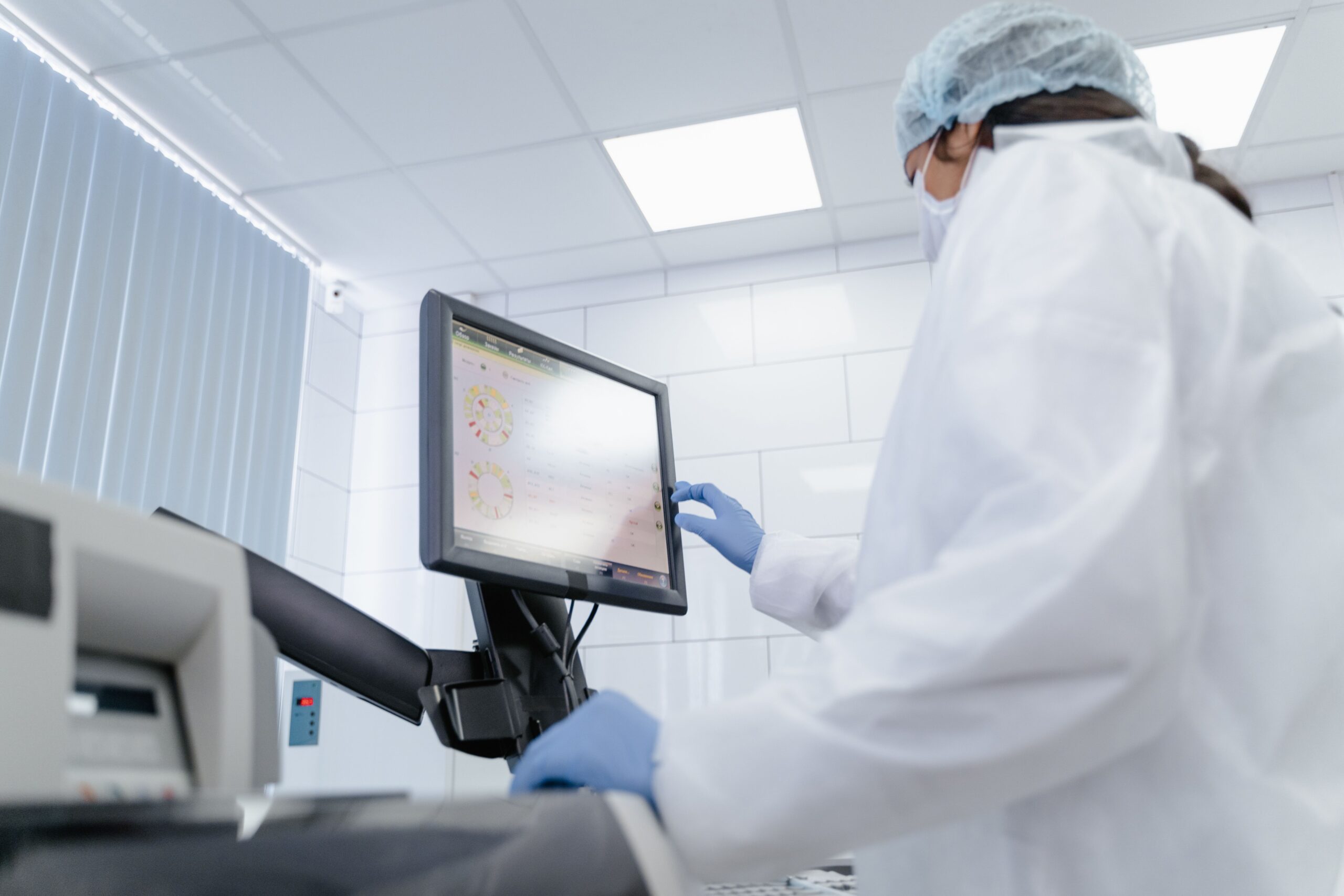 Insights Blog 4 Cleanroom technician using a touchscreen monitor, illustrating personnel as a primary source of triboelectric charge.