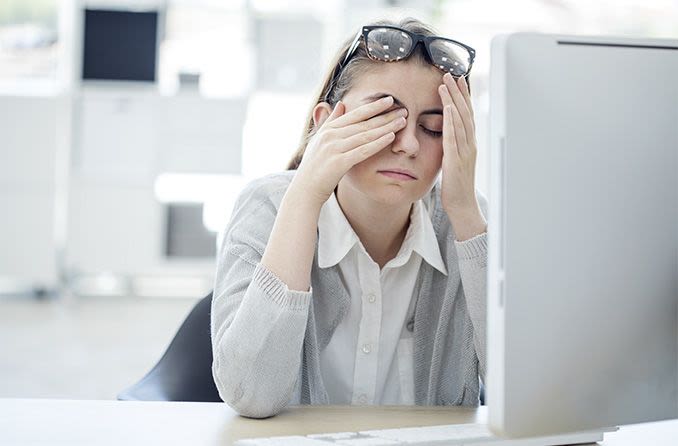 Insights Blog 5 Tired office worker at a desk, reflecting the eye strain and fatigue linked to low workplace humidity